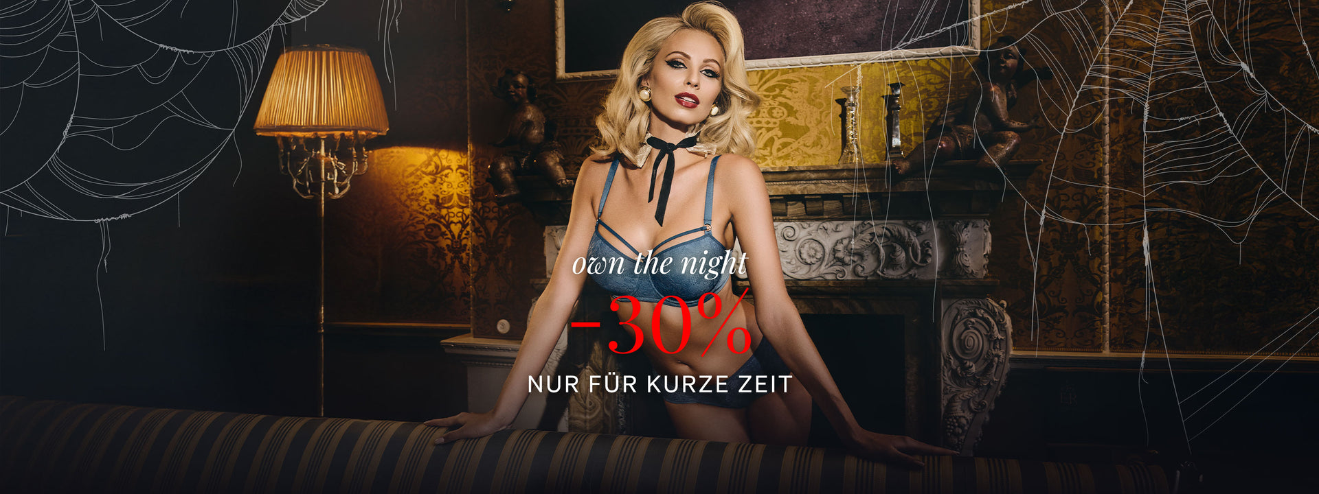 Blonde classy woman wearing the SO teal lace balcony bra from marlies|dekkers with promotional text overlay in a decorative setting for Halloween