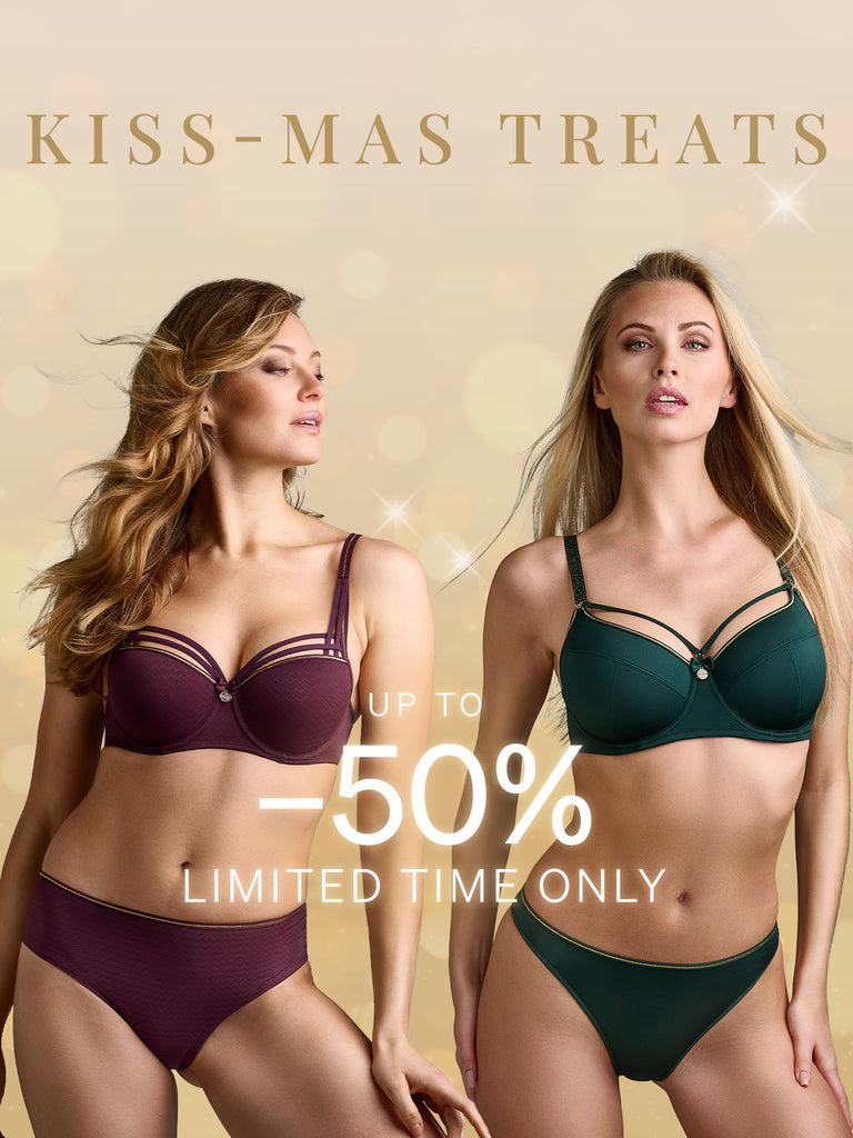 Two models wearing aubergine & green colored lingerie with sparkles in the background for Kiss-Mass treats promotion