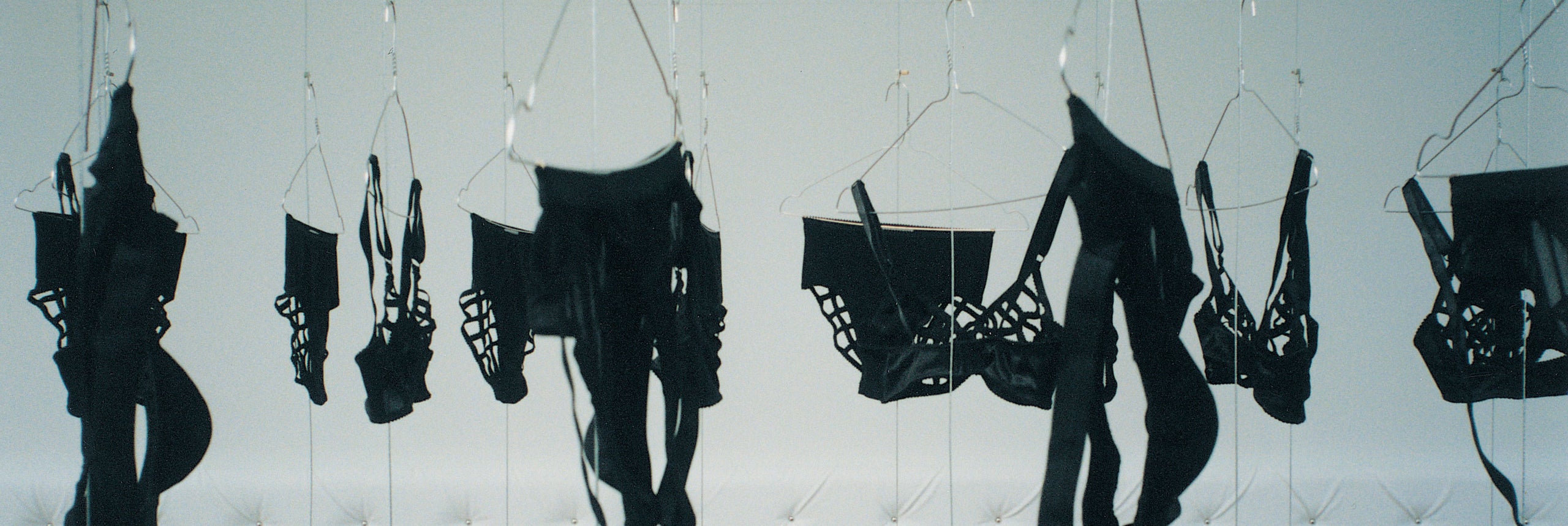 Black lingerie collection Marlies Dekkers called Spider hanging on a white quilted background